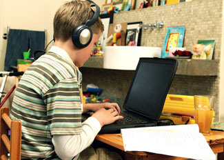 Student with headphones working on a computer