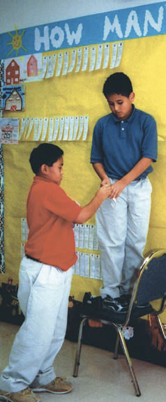 Photo of two boys putting up a banner at a school.