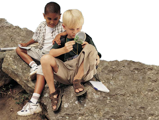 Photo of two boys looking at a plant through a magnifying glass.