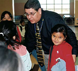 Photo of the school principal talking to several young female students.