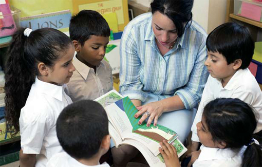 Photo of a teacher reading to several young students