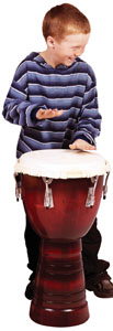 A photo of a boy playing the drums and learning about rhythm.