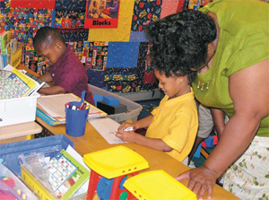 Preschoolers work in a writing center