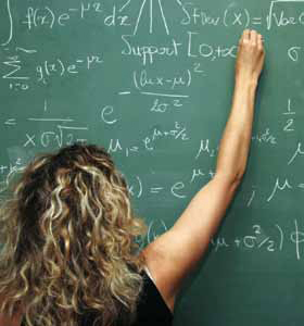 Photo of a girl writing a math equasion on the chalkboard.