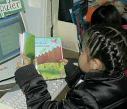 Photo of a girl at a computer reading a science lesson.
